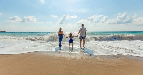 Can Foreigners Buy Insurance in Thailand? man, woman and child holding hands on seashore